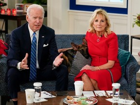 President Joe Biden, first lady Jill Biden and their dog Commander, a purebred German shepherd, meet virtually with service members around the world, Saturday, Dec. 25, 2021.