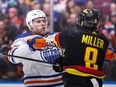 Edmonton Oilers' Connor McDavid, back left, checks Vancouver Canucks' J.T. Miller during the third period on November 6, 2023.