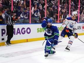Vancouver Canucks' Conor Garland, left, celebrates his goal as Edmonton Oilers' Darnell Nurse reacts during the third period in Game 1 at Rogers Arena on Wednesday night.