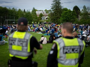 Vancouver Police officers watch over a crowd gathered to watch Vancouver Canucks play the Edmonton Oilers at a