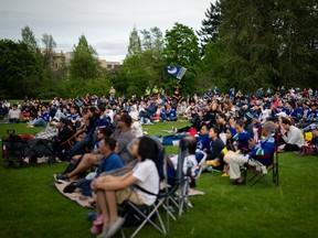 People gather for a Vancouver Canucks "Playoffs in the Park" viewing party for the third game in the second round of the Stanley Cup playoffs, in Vancouver, B.C., Sunday, May. 12, 2024.
