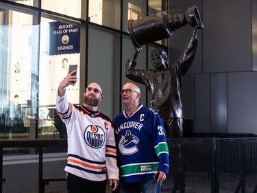 Fans take their picture with the Wayne Gretzky statue before the Edmonton Oilers take on the Vancouver Canucks during second-round NHL playoff action in Edmonton on Tuesday May 14, 2024.THE CANADIAN PRESS/Jason Franson