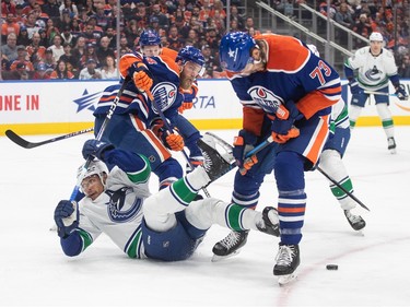 Vancouver Canucks' Dakota Joshua (81) is checked by Edmonton Oilers' Vincent Desharnais (73) during first period second-round NHL playoff action in Edmonton on Tuesday May 14, 2024.THE CANADIAN PRESS/Jason Franson