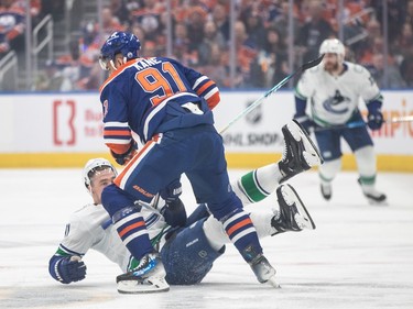 Vancouver Canucks' Nikita Zadorov (91) is checked by Edmonton Oilers' Evander Kane (91) during first period second-round NHL playoff action in Edmonton on Tuesday May 14, 2024.THE CANADIAN PRESS/Jason Franson