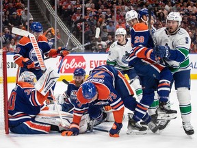 Vancouver Canucks and the Edmonton Oilers crash the net during first period second-round NHL playoff action in Edmonton on Tuesday May 14, 2024.THE CANADIAN PRESS/Jason Franson
