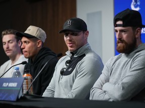 Vancouver Canucks' Ian Cole, second right, speaks as Filip Hronek, front right, Carson Soucy, back left, and Dakota Joshua listen during the NHL hockey team's end of season news conference, in Vancouver, B.C., Thursday, May 23, 2024.