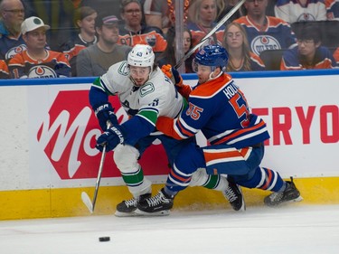 Dylan Holloway (55) of the Edmonton Oilers, checks Quinn Hughes (43) of the Vancouver Canucks at Rogers Place in Edmonton on May 12, 2024.  Photos by Shaughn Butts-Postmedia