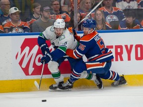 Dylan Holloway (55) of the Edmonton Oilers, checks Quinn Hughes (43) of the Vancouver Canucks at Rogers Place in Edmonton on May 12, 2024. Photos by Shaughn Butts-Postmedia