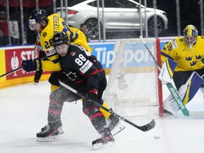 Sweden's Marcus Pettersson, left, challenges Canada's Andrew Mangiapane during the bronze medal match between Sweden and Canada at the Ice Hockey World Championships in Prague, Czech Republic, Sunday, May 26, 2024.