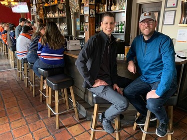 VANCOUVER, May 14, 2024 -- Oilers fans Karl Mikusek (left) and Tyler Herbert wish they'd thought to pack their Oilers jerseys for their business trips to Vancouver, at Gastown's Black Frog Eatery. PHOTO BY GORD MCINTYRE
