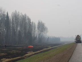 The mayor of the regional municipality that includes the evacuated community of Fort Nelson, B.C., says local officials are pushing for a Monday or Tuesday deadline to start allowing about 4,700 residents home after nearly two weeks. Firefighters working the Parker Lake wildfire, designated G90267 by the B.C. Wildfire Service, are seen in a staging area along Highway 97 looking south with a water bladder and fire hose set up among charred grassland in a May 15, 2024, handout photo.