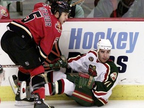 Calgary Flames defenceman Steve Montador (5) knocks Minnesota Wild forward Pascal Dupuis (11) as Dupuis looks for a call from the referee in the first period in Calgary, November 7, 2003. There was no call on the play.n/a ORG XMIT: CGY01D