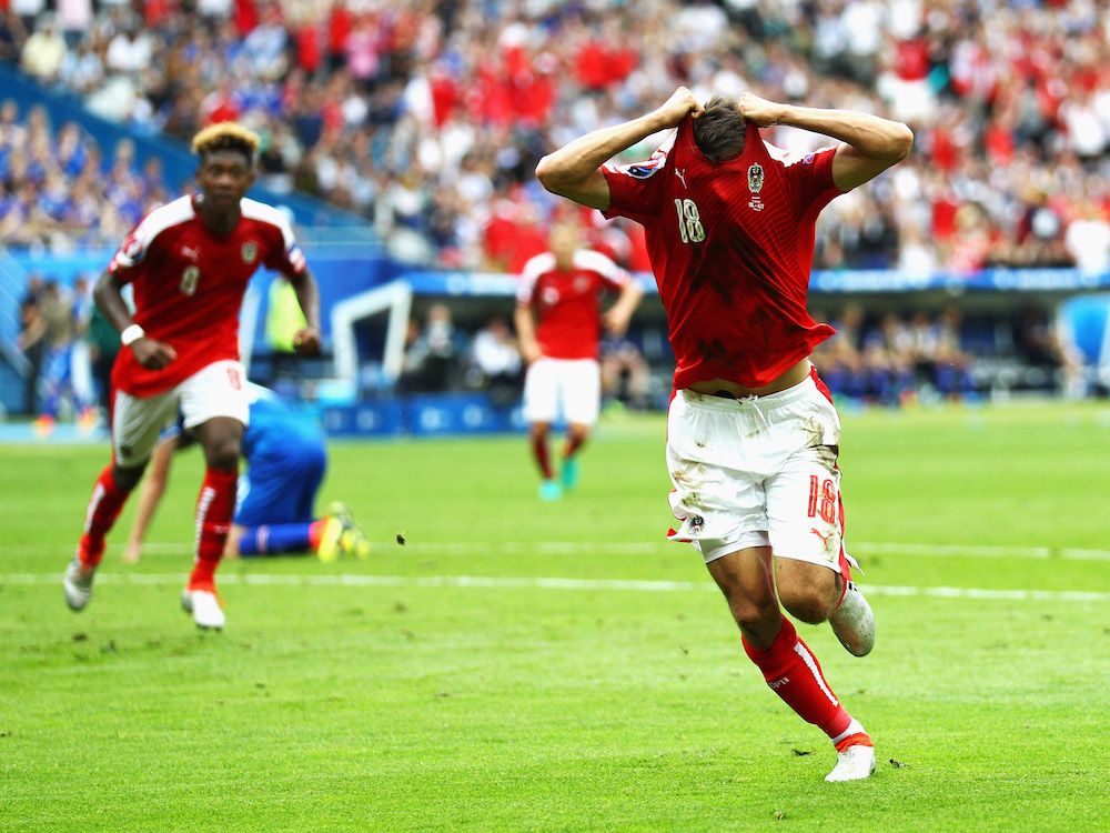 Alessandro Schöpf pulls his shirt over his head.