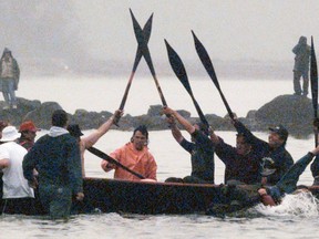 Makah Natives raise their paddles in victory upon reaching the beach in Neah Bay, Washington in May, 1999. The Makah natives finally made their whale kill this morning, off the Olympic Peninsula.