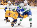 Vancouver Canucks center Teddy Blueger (53) hits Nashville Predators center Ryan O'Reilly (90) to the ice during the second period in Game 4 of an NHL hockey Stanley Cup first-round playoff series Sunday, April 28, 2024, in Nashville, Tenn.