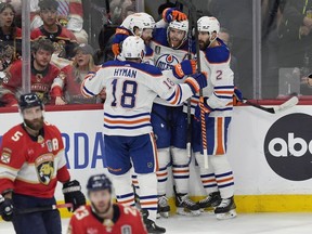 Edmonton Oilers centre Connor McDavid (97), is congratulated by his teammates after scoring a goal during the second period of Game 5 of the NHL hockey Stanley Cup final against the Florida Panthers, Tuesday, June 18, 2024, in Sunrise, Fla.