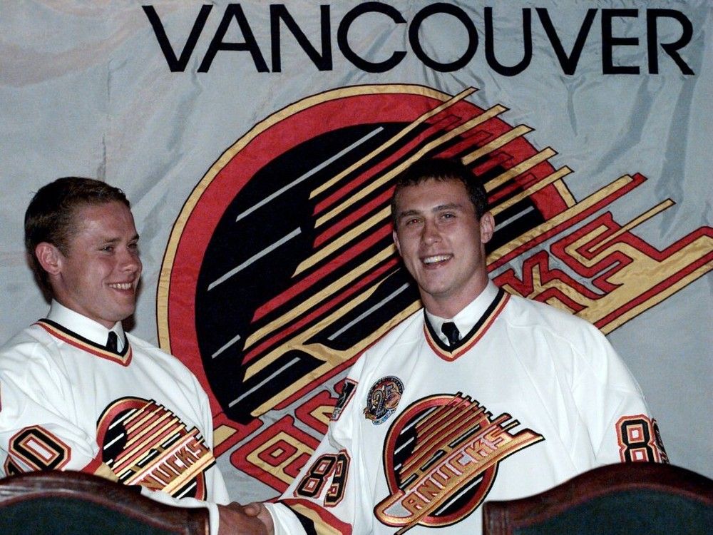 Alexander Mogilny (R) shakes Pavel Bure's hand at the Hyatt Regency Hotel in 1995.