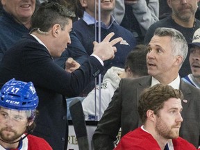 MONTREAL, QUE.: March 21, 2023 -- Montreal Canadiens head coach Martin St. Louis, right, listens to assistant coach Alex Burrows during National Hockey League game against the Tampa Bay Lightning in Montreal Tuesday March 21, 2023.