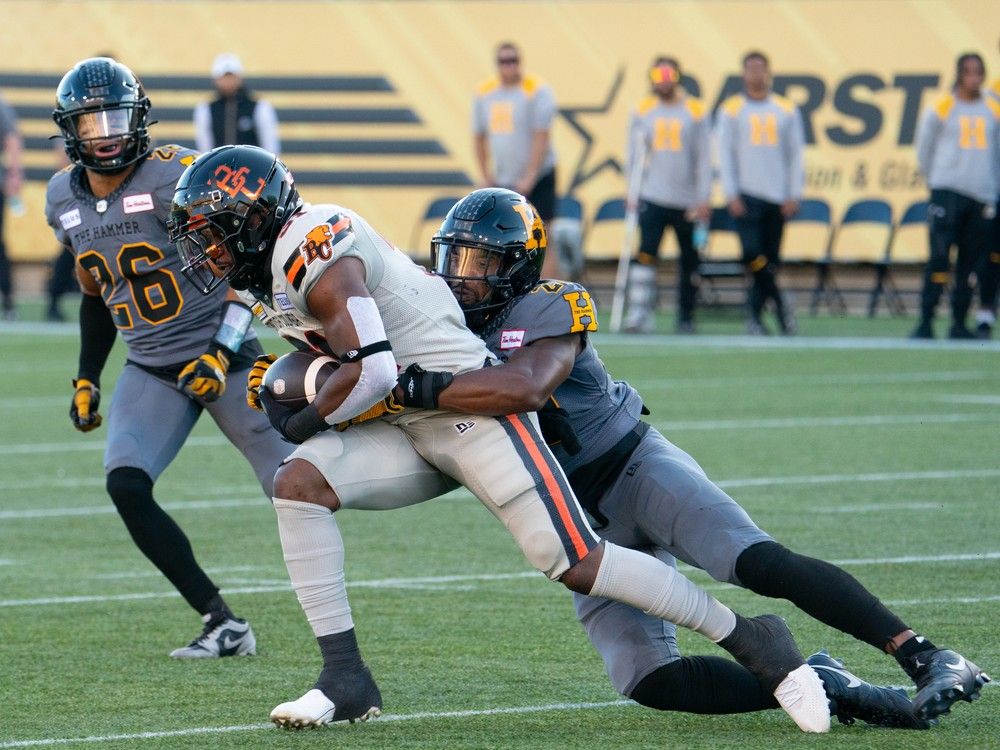 BC Lions running back William Stanback (31) is tackled by Hamilton Tiger Cats linebacker DQ Thomas (20) during first quarter CFL football game action in Hamilton, Ont. on Sunday, July 7, 2024.