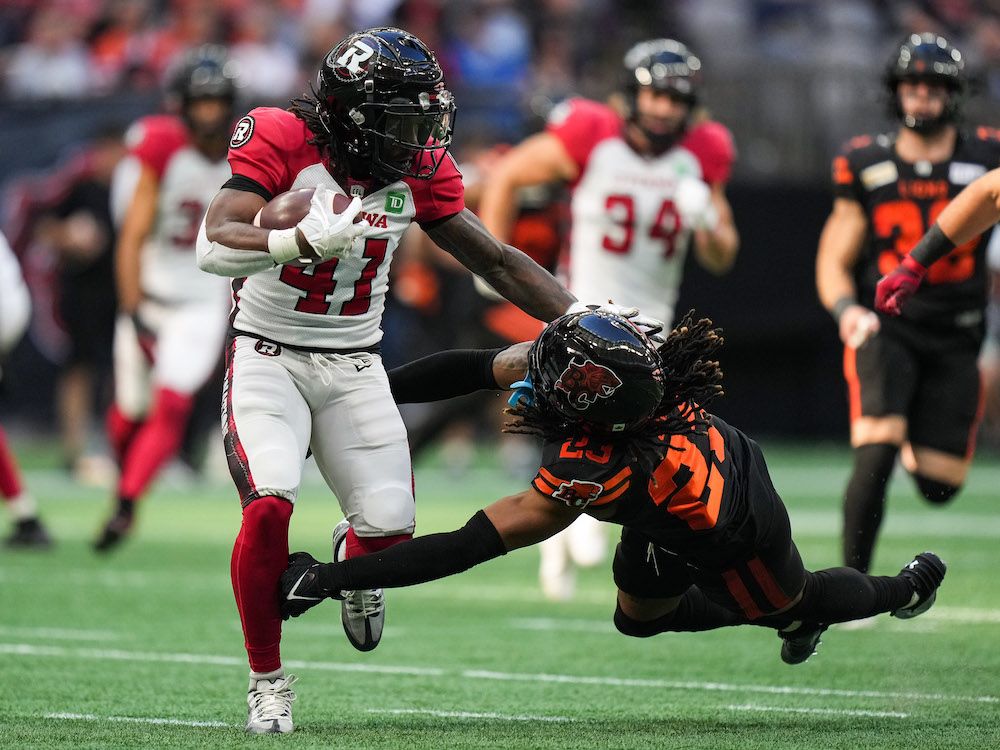 Ottawa Redblacks' Tobias Harris, left, is tackled by B.C. Lions' Adrian Greene as he returns a kick during the first half of a CFL football game in Vancouver last September. 
