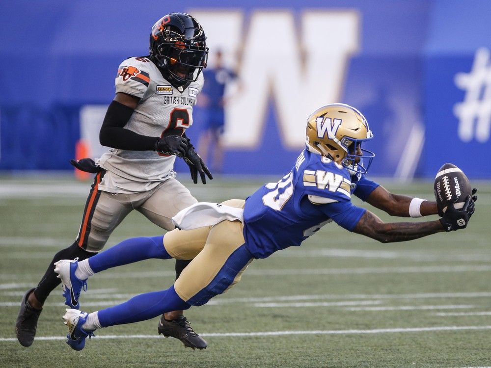 Winnipeg Blue Bombers' Ontaria Wilson (80) catches the pass as B.C. Lions' T.J. Lee (6) defends during first half CFL action in Winnipeg Thursday, August 1, 2024.