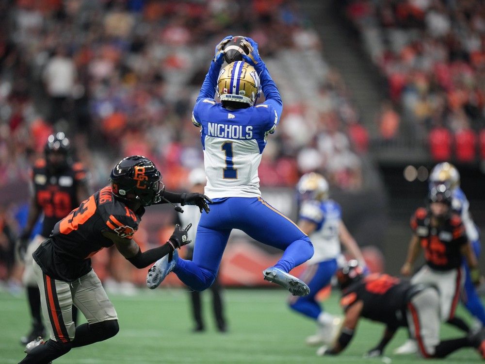 Winnipeg Blue Bombers' Deatrick Nichols (1) intercepts a pass intended for B.C. Lions' Alexander Hollins (13) during the first half of a CFL football game, in Vancouver, B.C., Sunday, Aug. 18, 2024.
