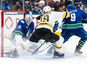 Vancouver Canucks goaltender Thatcher Demko (35) stops Boston Bruins' John Beecher (19) as Vancouver's J.T. Miller (9) watches during the second period of an NHL hockey game in Vancouver, B.C., Saturday, Dec. 14, 2024.