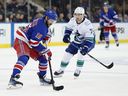 Vincent Trocheck #16 of the New York Rangers controls the puck as Nils Hoglander #21 of the Vancouver Canucks defends during the second period at Madison Square Garden on March 22, 2025 in New York City.