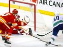 Elias Pettersson scores on Flames goalie Dustin Wolf in the third period.