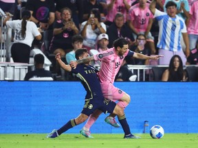 Lionel Messi #10 of Inter Miami CF and Andrés Cubas #20 of the Vancouver Whitecaps FC battle for the ball during the CONCACAF Champions Cup Semi-final Second Leg match between Inter Miami CF and Vancouver Whitecaps at Chase Stadium on April 30, 2025 in Fort Lauderdale, Florida.