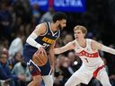 Denver Nuggets guard Jamal Murray (27) and Toronto Raptors guard Gradey Dick (1) in the second half of an NBA basketball game Monday, March 11, 2024, in Denver. Toronto opens the season on Oct. 23 at home to the Cleveland Cavaliers and host Jamal Murray of Kitchener, Ont., and the Denver Nuggets on Oct. 28.