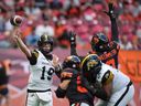 Hamilton Tiger-Cats quarterback Bo Levi Mitchell (19) passes the ball as B.C. Lions' Deontai Williams (9) gets his hands up to try and knock the ball down during the first half of a CFL football game, in Vancouver, on Sunday, July 27, 2025.
