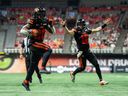 B.C. Lions' James Butler (20) scores a touchdown against the Edmonton Elks as B.C. Lions quarterback Nathan Rourke (12) cheers during the second half of a CFL football game in Vancouver, on Saturday, June 7, 2025.