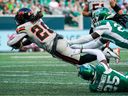 B.C. Lions running back James Butler is tackled by Saskatchewan Roughriders defensive back Kerfalla-Emmanuel Exume and defensive back Nelson Lokombo during CFL game in Regina, June 28, 2025.