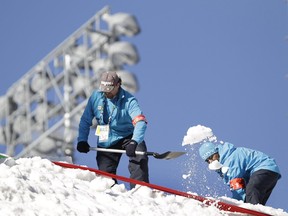 Volunteers prepare the jump for the women's freestyle skiing aerials qualifications at the Vancouver 2010 Olympics in Vancouver, British Columbia, Saturday, Feb. 20, 2010.