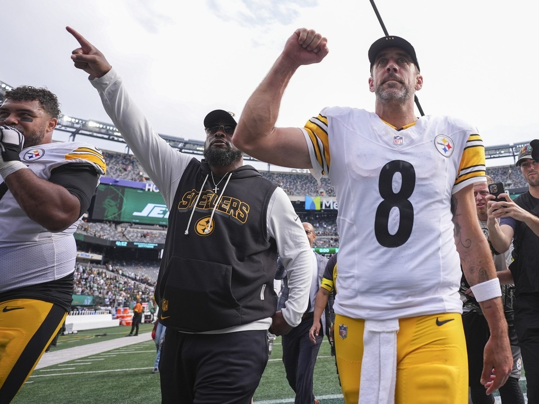 Pittsburgh Steelers defensive tackle Cam Heyward (97), head coach Mike Tomlin, center, and quarterback Aaron Rodgers (8) leave the field following an NFL football game against the New York Jets on Sunday.