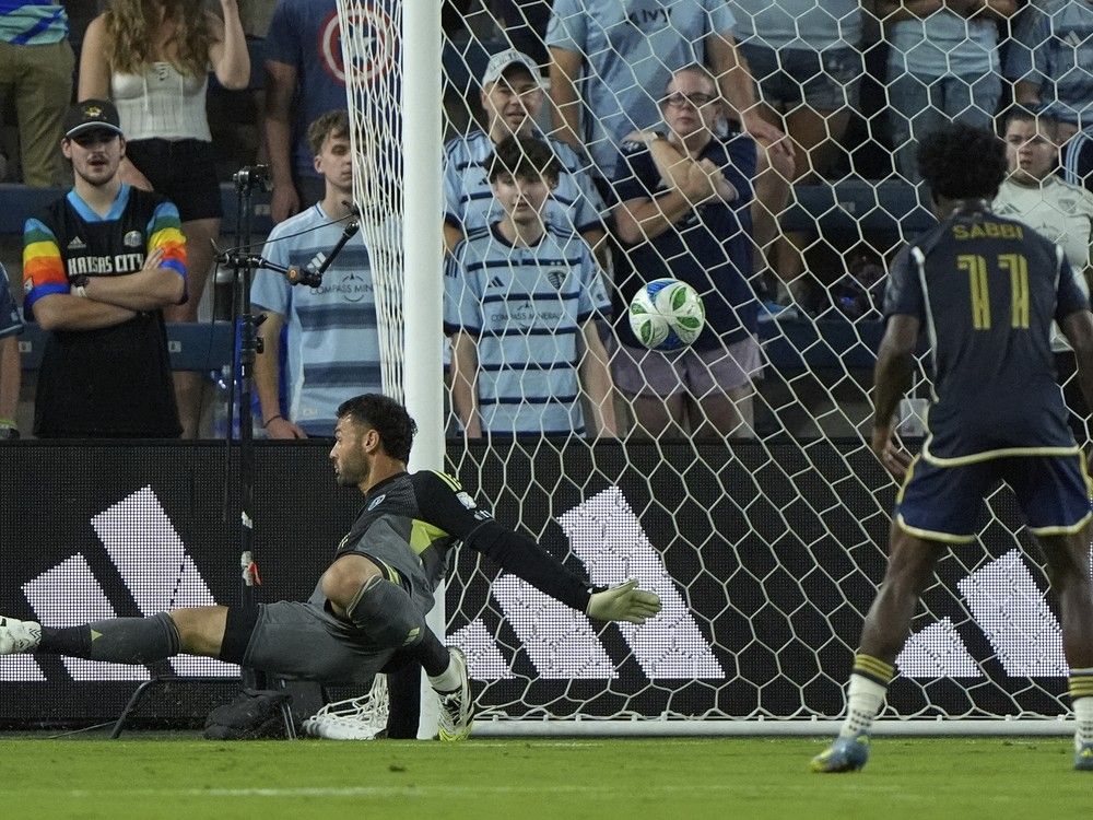 A ball kicked by Vancouver Whitecaps midfielder Kenji Cabrera gets past Sporting Kansas City goalkeeper John Pulskamp, left, to score during MLS match Sept. 20, 2025, in Kansas City, Kan.