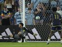 A ball kicked by Vancouver Whitecaps midfielder Kenji Cabrera gets past Sporting Kansas City goalkeeper John Pulskamp, left, to score during MLS match Sept. 20, 2025, in Kansas City, Kan.