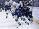 Vancouver Canucks defenceman Tom Willander (5) and Seattle Kraken forward Jake O'Brien vie for the puck during a preseason game this year.