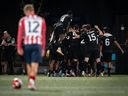 Vancouver FC celebrates Nicolas Mezquida's goal against Ottawa Atletico as Ottawa Atletico's Monty Patterson (12) watches during second half Canadian Championship semifinal soccer action, in Langley, B.C., on Wednesday, August 13, 2025.