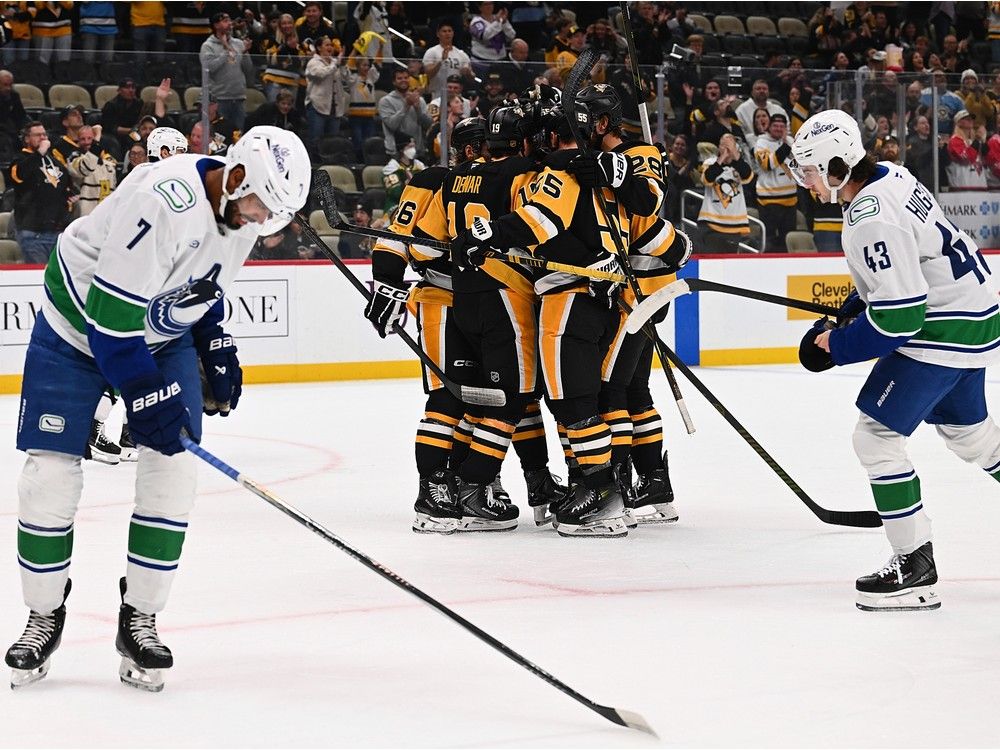 Connor Dewar #19 of the Pittsburgh Penguins celebrates with teammates after scoring a goal in the first period against the Vancouver Canucks at PPG PAINTS Arena on October 21, 2025 in Pittsburgh.