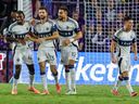 Vancouver Whitecaps forward Thomas Müller celebrates with teammates Nelson Pierre, Belal Halbouni and Sebastian Berhalter after he scored the second goal against Orlando City during the second half of an MLS soccer match, Saturday, Oct. 11, 2025, in Orlando, Fla.