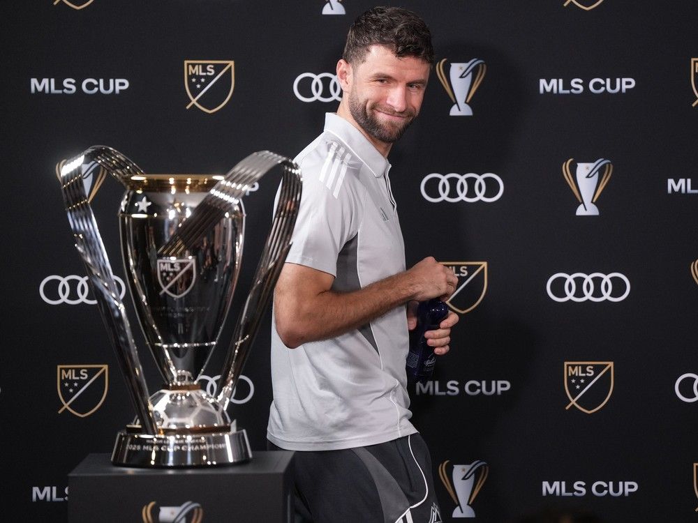 Thomas Muller looks at the Cup trophy as he arrives for a news conference ahead of the MLS final soccer match, in Fort Lauderdale, Fla. earlier this week.