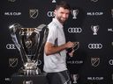 Thomas Muller looks at the Cup trophy as he arrives for a news conference ahead of the MLS final soccer match, in Fort Lauderdale, Fla. earlier this week.