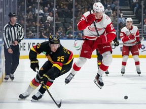 Detroit Red Wings' Nate Danielson (29) jumps to avoid Elias Pettersson (25) as they vie for the puck during the first period