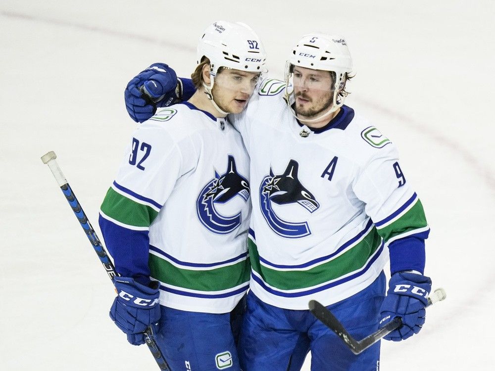 Vancouver Canucks players J.T. Miller and Vasily Podkolzin share a celebratory moment on the ice.