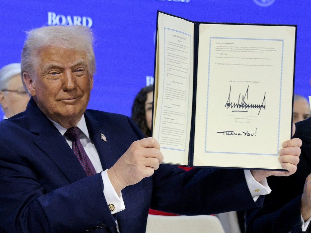U.S. President Donald Trump holds up his signature during a signing ceremony for the "Board of Peace" at the World Economic Forum (WEF) on Thursday in Davos, Switzerland.