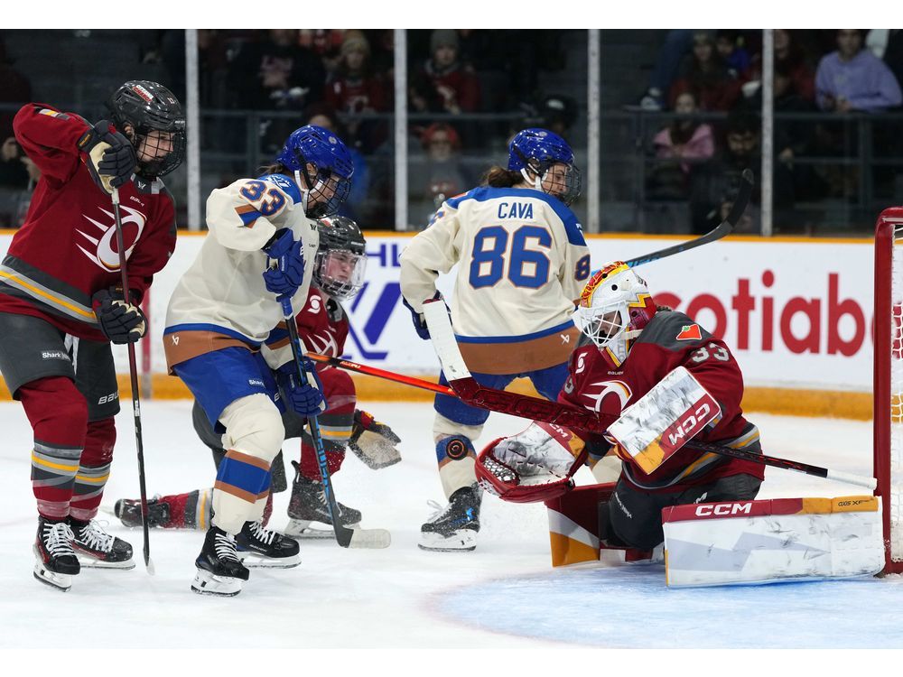 Ottawa Charge goaltender Gwyneth Philips looks for the save in front of Vancouver Goldeneyes' Michelle Karvinen (33) and Michela Cava (86) during PWHL action in Ottawa on Nov. 26, 2025.