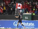 Canada's Alistair Johnston (2) parades the flag to celebrate the win over Mexico in Edmonton in 2021. The Reds are going back to Commonwealth Stadium this June to play a World Cup warmup match against Uzbekistan.