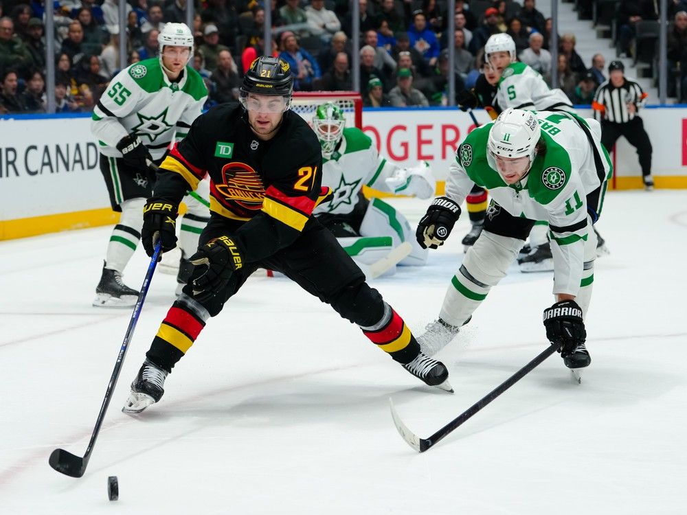 Nathan Bastian #11 of the Dallas Stars defends against Nils Hoglander #21 of the Vancouver Canucks during the first period at Rogers Arena on March 2, 2026 in Vancouver, British Columbia, Canada.